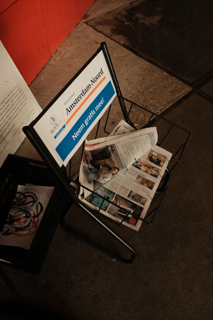 Metal stand with free newspapers in Amsterdam. Urban street scene with industrial style.